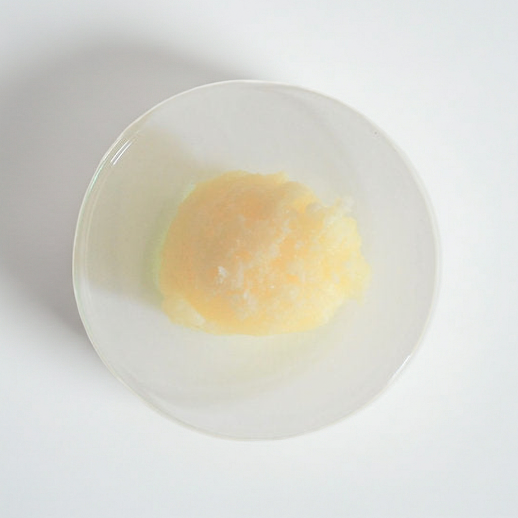 Weiche, leicht gelbliche Sheabutter Nilotica in weißer Schale auf hellem Hintergrund – besonders schmelzende Bio-Karitébutter aus Uganda